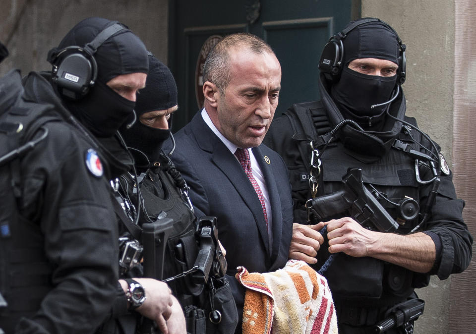 FILE - In this Thursday, Jan. 12, 2017 file photo, Former Prime Minister of Kosovo Ramush Haradinaj, center, leaves the court escorted by hooded police officers in Colmar, eastern France. Kosovo’s prime minister has resigned from the post after he has been invited to be questioned from a European Union-funded court investigating crimes against ethnic Serbs during and after the 1998-99 independence war with Serbia. Haradinaj said on Friday, July 19, 2019 he had informed the Cabinet of his resignation and urged the country’s president to set a date for an early parliamentary election. (AP Photo/Jean-Francois Badias)