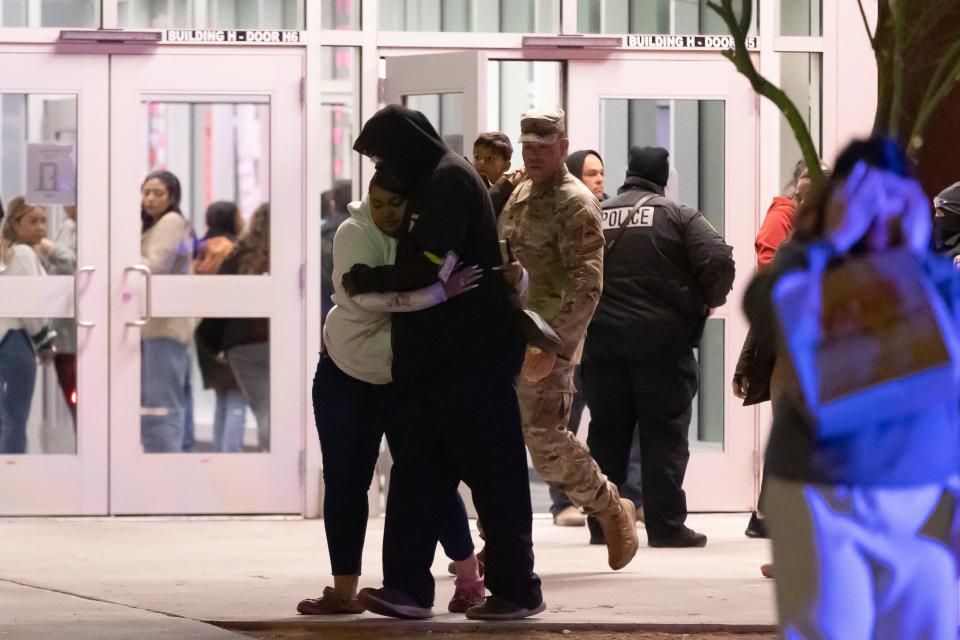 Shoppers who were inside Cielo Vista Mall during the shooting are reunited with family members at Burges High School in East-Central El Paso on Wednesday.