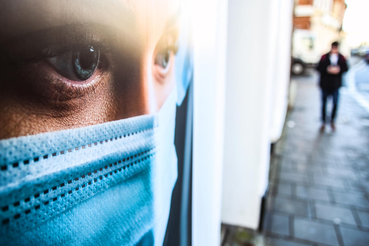A man walks past a window display that shows an NHS worker wearing a protective face mask in Worthing, Sussex, as the UK continues in a third lockdown due to the coronavirus pandemic. Picture date: Tuesday February 23, 2021.