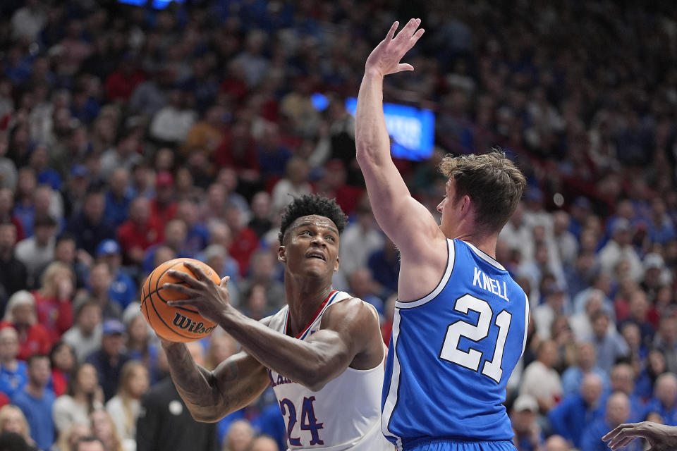 Kansas forward K.J. Adams Jr. (24) looks to shoot over BYU guard Trevin Knell (21) during the first half of an NCAA college basketball game Tuesday, Feb. 27, 2024, in Lawrence, Kan. (AP Photo/Charlie Riedel)