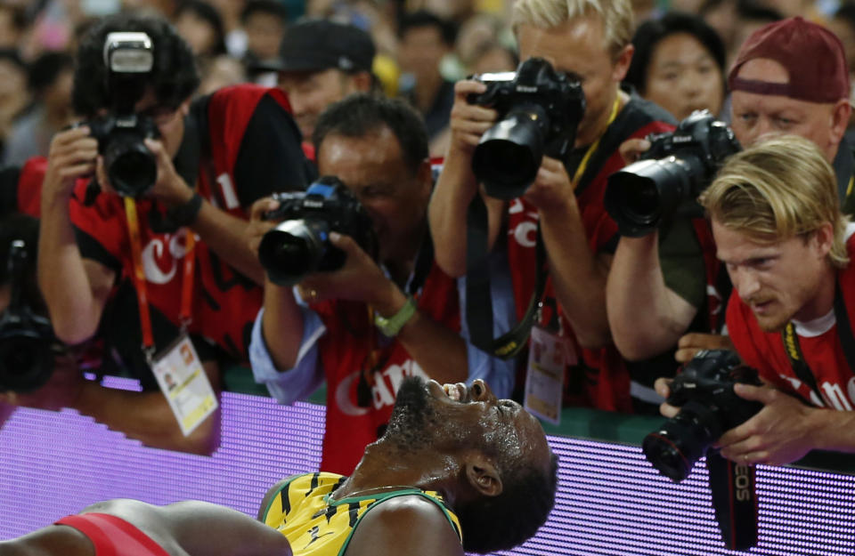 Photographers take pictures of Usain Bolt of Jamaica after he won the men's 200 metres final during the 15th IAAF World Championships at the National Stadium in Beijing