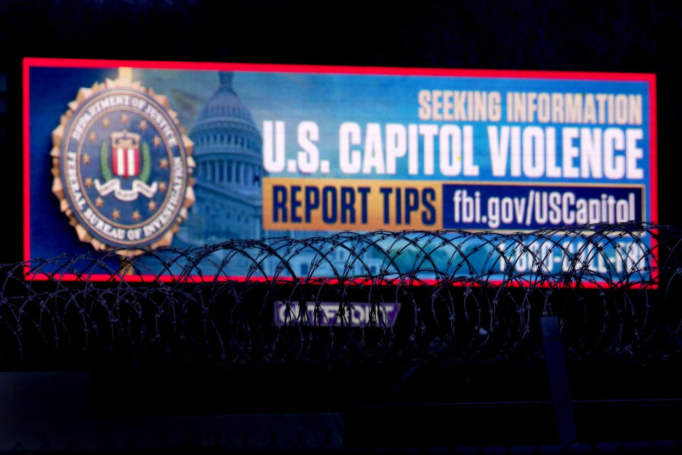 A billboard seeking tips about rioters who breached the United States Capitol Building on Jan. 6 stands along Interstate 35 Saturday, Jan. 16, 2021, in Kansas City, Kan. (AP Photo/Charlie Riedel)