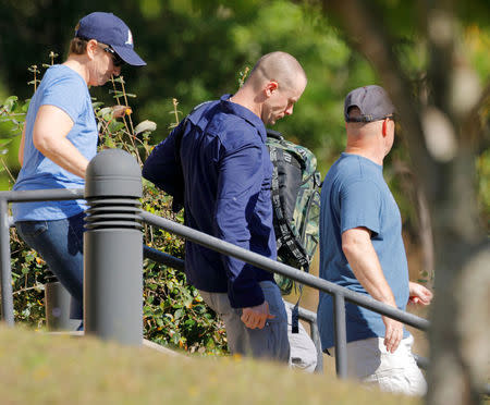 Bowe Bergdahl (C), who was demoted and dishonorably discharged from the U.S. Army for abandoning his post in Afghanistan, wears civilian clothes as he is escorted out of the courthouse at the conclusion of his court martial at Fort Bragg, North Carolina, U.S., November 3, 2017. REUTERS/Jonathan Drake