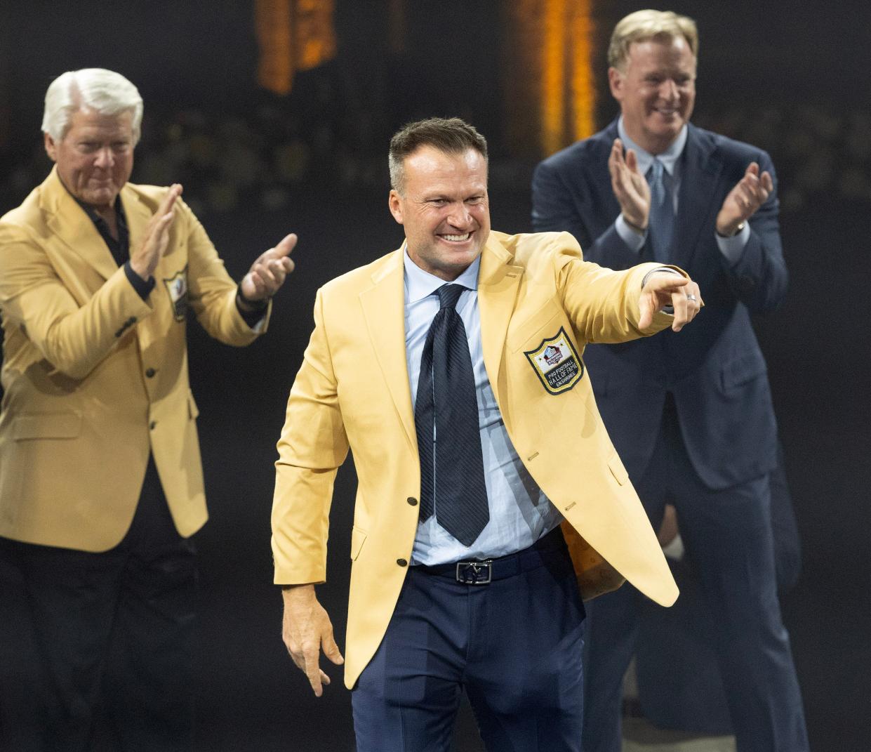 Zach Thomas celebrates after receiving his gold jacket from Hall of Famer Jimmie Johnson, left, and NFL Commissioner Roger Goodell on Friday in Canton.