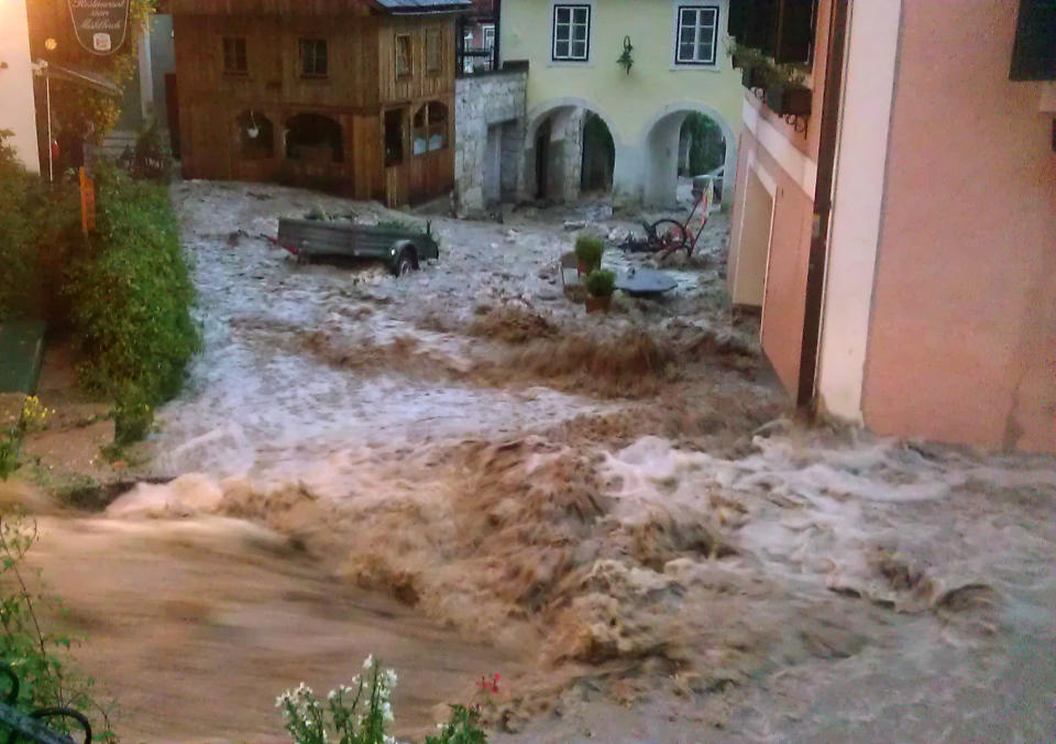 In this picture provided by Hallstatt.net flood rushes down a street in the village of Hallstatt, Austria, Wednesday, June 19, 2013. A flash flood unleashed by a major thunder storm has inundated the village, which has been awarded special status by the U.N. because of its unique beauty. Wednesday’s storm turned the placid village creek into a raging torrent that flooded the village square, tearing up cobble stones in its wake. Houses and a hotel are partially under water. (AP Photo/Hallstatt.net, Werner Krauss) BEST QUALITY AVAILABLE