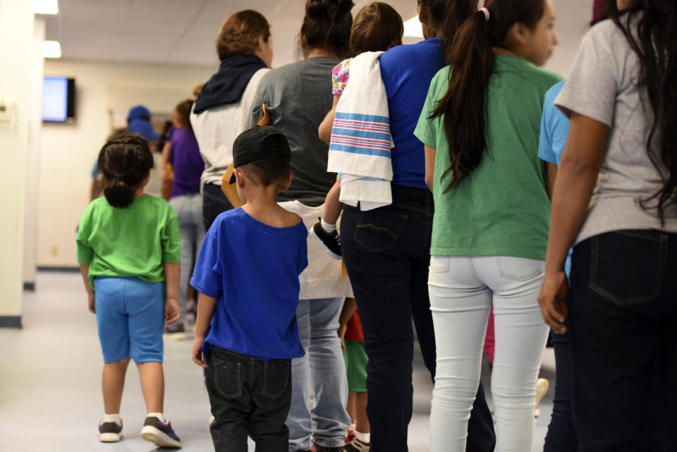 In this Aug. 9, 2018 photo provided by U.S. Immigration and Customs Enforcement, mothers and their children stand in line at South Texas Family Residential Center in Dilley, Texas. The family detention center is run as a for-profit business by CoreCivic, the country's largest private prison contractor. (Photo: ASSOCIATED PRESS)