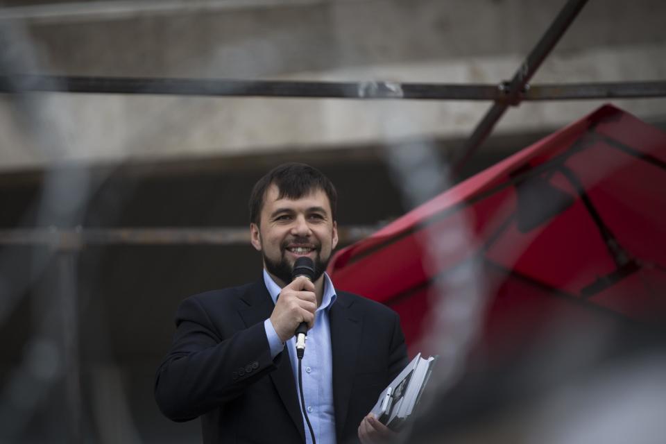 Denis Pushilin, spokesman of the self-appointed Donetsk People’s Republic, speaks to a crowd at barricades in front of a regional administration building that was seized by pro-Russian activists earlier in Donetsk, Ukraine, Sunday, April 20, 2014. The Ukrainian and Russian governments are reporting a shootout at a checkpoint set up by pro-Russian insurgents in eastern Ukraine that has left one person dead and others hospitalized with gunshot wounds. (AP Photo/Alexander Zemlianichenko)