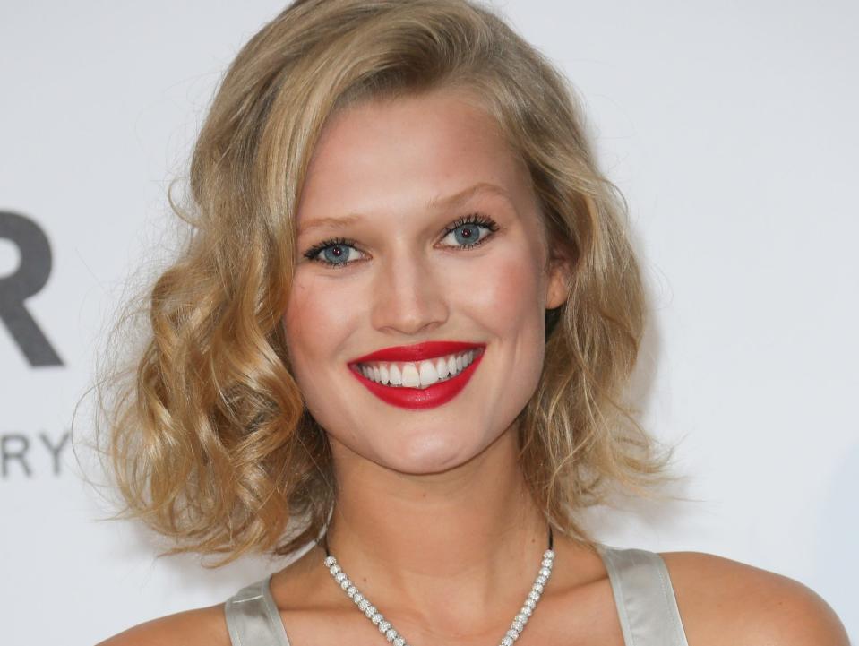 Toni Garrn smiles for a photo during a red carpet event in 2014.