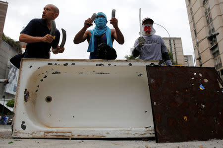 Opposition supporters bang a metal barricade during a rally against Venezuela's President Nicolas Maduro in Caracas, Venezuela April 24, 2017. REUTERS/Carlos Garcia Rawlins