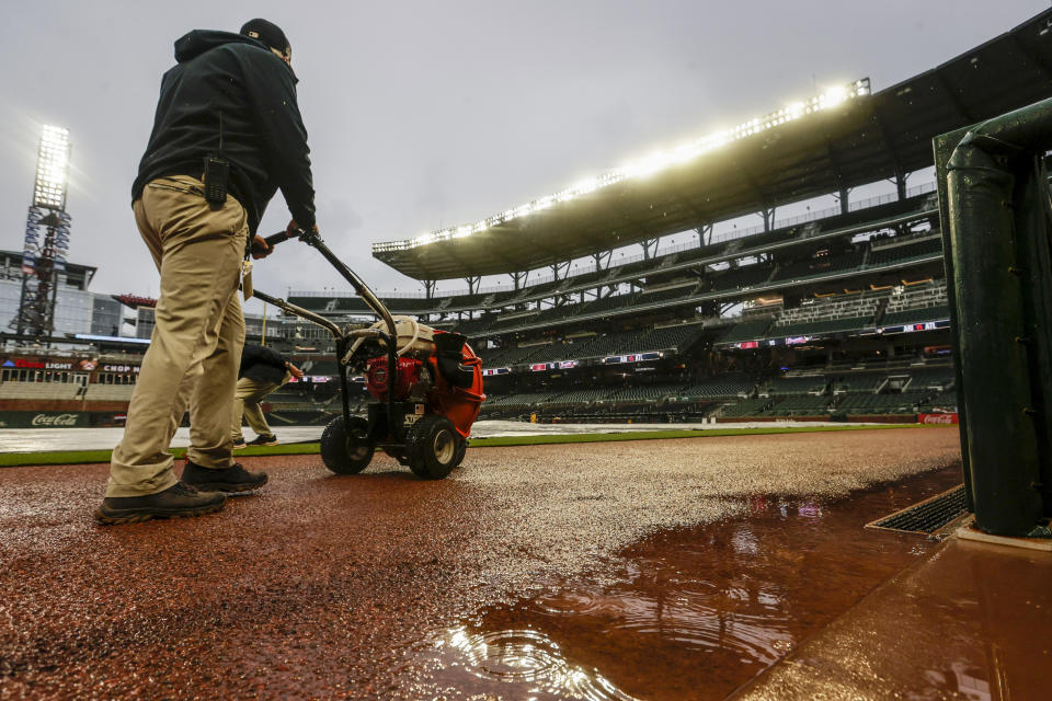 Grounds crew prepare the field after a thunderstorm passed through before a baseball game between the Atlanta Braves and the Arizona Diamondbacks, Saturday, July 30, 2022, in Atlanta. (AP Photo/Butch Dill)