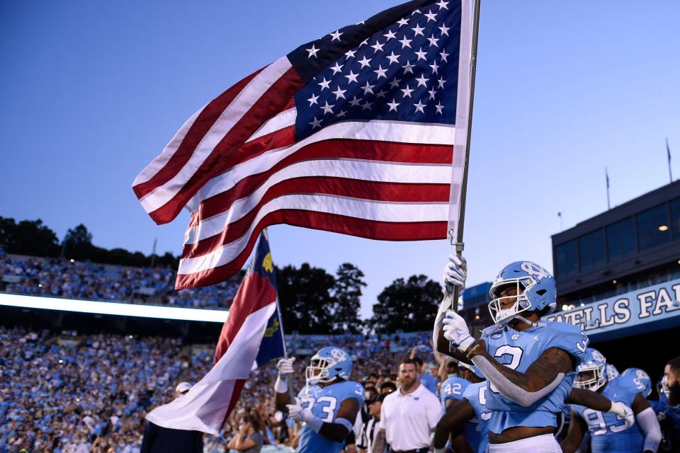 North Carolina receiver Antoine Green, front right, and linebacker Cedric Gray, left, lead the way as the Tar Heels take the field for their 2021 home opener against Georgia State.