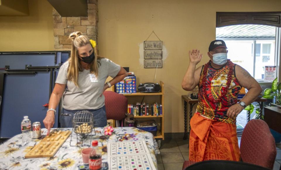 Volunteer Chrissy Metcalf calls bingo as Pepe Iossa dances a the Inn Between.