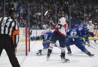 Washington Capitals' Tom Wilson, front, scores against Vancouver Canucks goalie Casey DeSmith (29) as Filip Hronek (17) and Ian Cole (82) defend during the second period of an NHL hockey game in Vancouver, British Columbia, Saturday, March 16, 2024. (Darryl Dyck/The Canadian Press via AP)