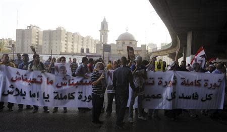 Members of the Muslim Brotherhood and supporters of ousted Egyptian President Mohamed Mursi shout slogans against the military and interior ministry, as they show the "Rabaa" or "four" gesture, in reference to the police clearing of Rabaa al-Adawiya protest camp on August 14, during a rally in the southern suburb of Maadi September 3, 2013. The banner reads, "The revolution continues, we will not tire and will continue to the end against corruption."REUTERS/Amr Abdallah Dalsh