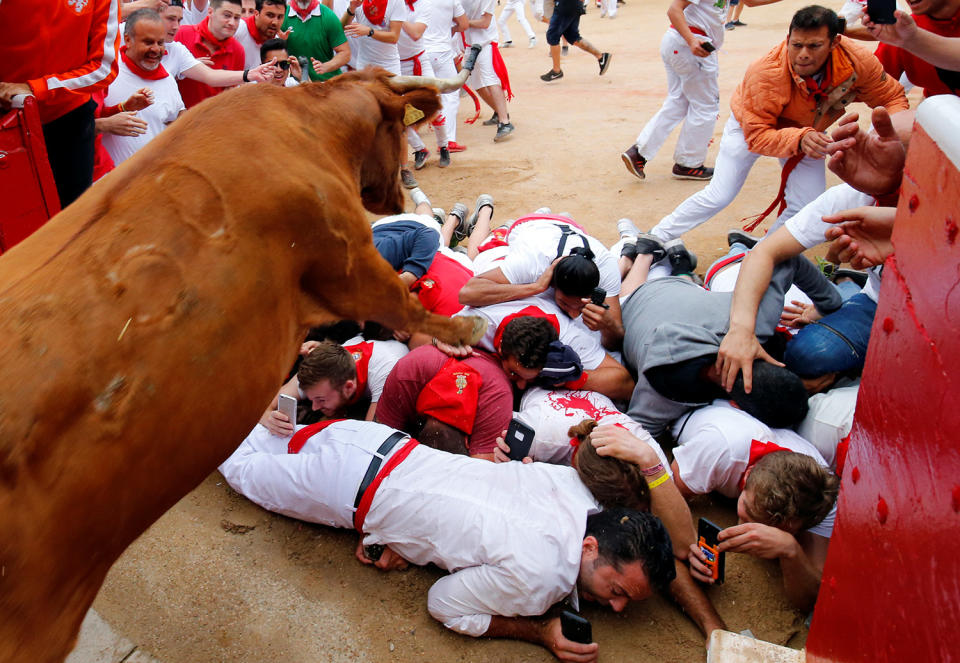 <p>A wild cow leaps over revellers as it enters the bullring following the seventh running of the bulls at the San Fermin festival in Pamplona, northern Spain, July 13, 2017. (Photo: Susana Vera/Reuters) </p>