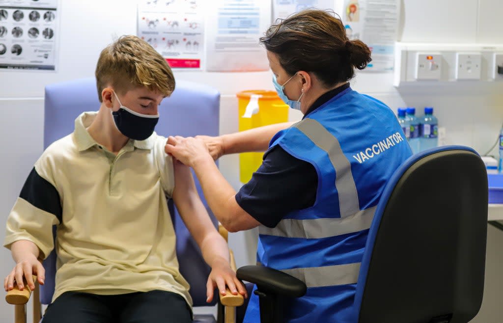 Kevin Mckeon, 14, receives his first dose of the Covid-19 vaccine from vaccinator Geraldine Flynn at the Citywest vaccination centre in Dublin (Damien Storan/PA) (PA Wire)