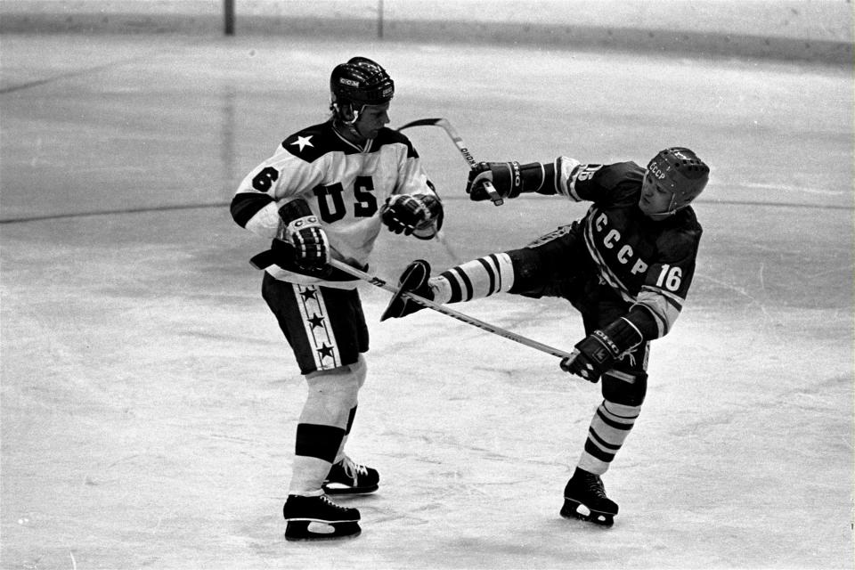 FILE In this Feb. 22, 1980 file photo Soviet forward Vladimir Petrov is trapped by stick of USA's William Baker which sticks between shoe and blade of the Soviet player; scene from second period of the USA vs. USSR ice hockey playoff round game at the Winter Olympics in Lake Placid, N.Y. Vladimir Petrov, a two-time Olympic hockey champion who was on the Soviet Union team that lost to the United States at the 1980 Lake Placid Games, died Tuesday. He was 69. (AP Photo, File)