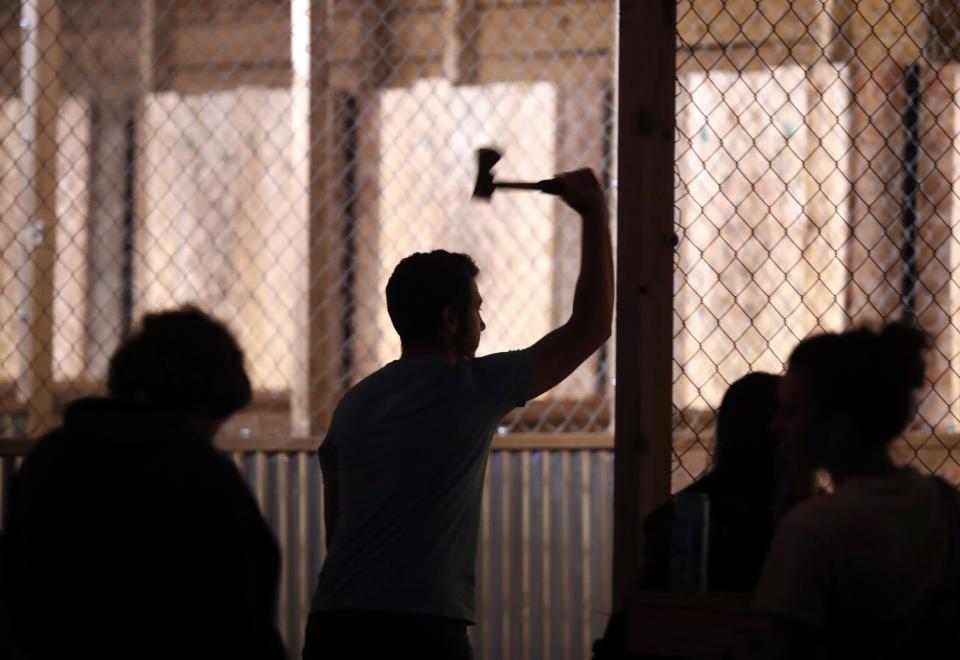 People try ax throwing at Constitution Yards, the shipping container complex that is part bar, part backyard barbecue on a recent Saturday night along the Wilmington Riverfront.