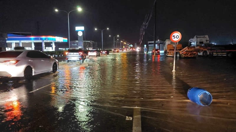 受低壓帶影響，嘉義地區10日午後降下大雨，導致國道1號嘉義交流道路段、嘉義縣民雄鄉、新港鄉等多處發生積淹水。圖為多輛汽車入夜後行經積水道路。（中央社／民眾提供）
