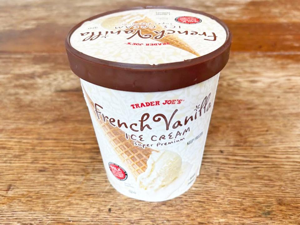 A white pint of ice cream with a picture of a vanilla ice-cream cone and Trader Joe's logo on the front. The lid has a brown band