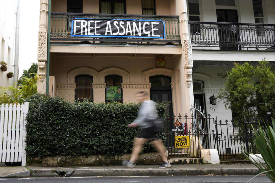 FILE - A pedestrian walks past a house with a sign in support of WikiLeaks founder Julian Assange in Sydney, Australia, on June 20, 2022. Australia's Prime Minister Anthony Albanese said, Wednesday, Nov. 30, 2022, that he had recently told U.S. President Joe Biden's administration to bring Wikileaks founder and Australian citizen Julian Assange's prosecution to a close.(AP Photo/Mark Baker, File)