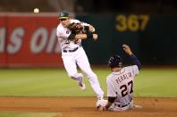 Jhonny Peralta #27 of the Detroit Tigers slides into second base and is out as Cliff Pennington #2 of the Oakland Athletics throws to first base trying to turn a double play in the fifth inning during Game Three of the American League Division Series at Oakland-Alameda County Coliseum on October 9, 2012 in Oakland, California. (Photo by Ezra Shaw/Getty Images)