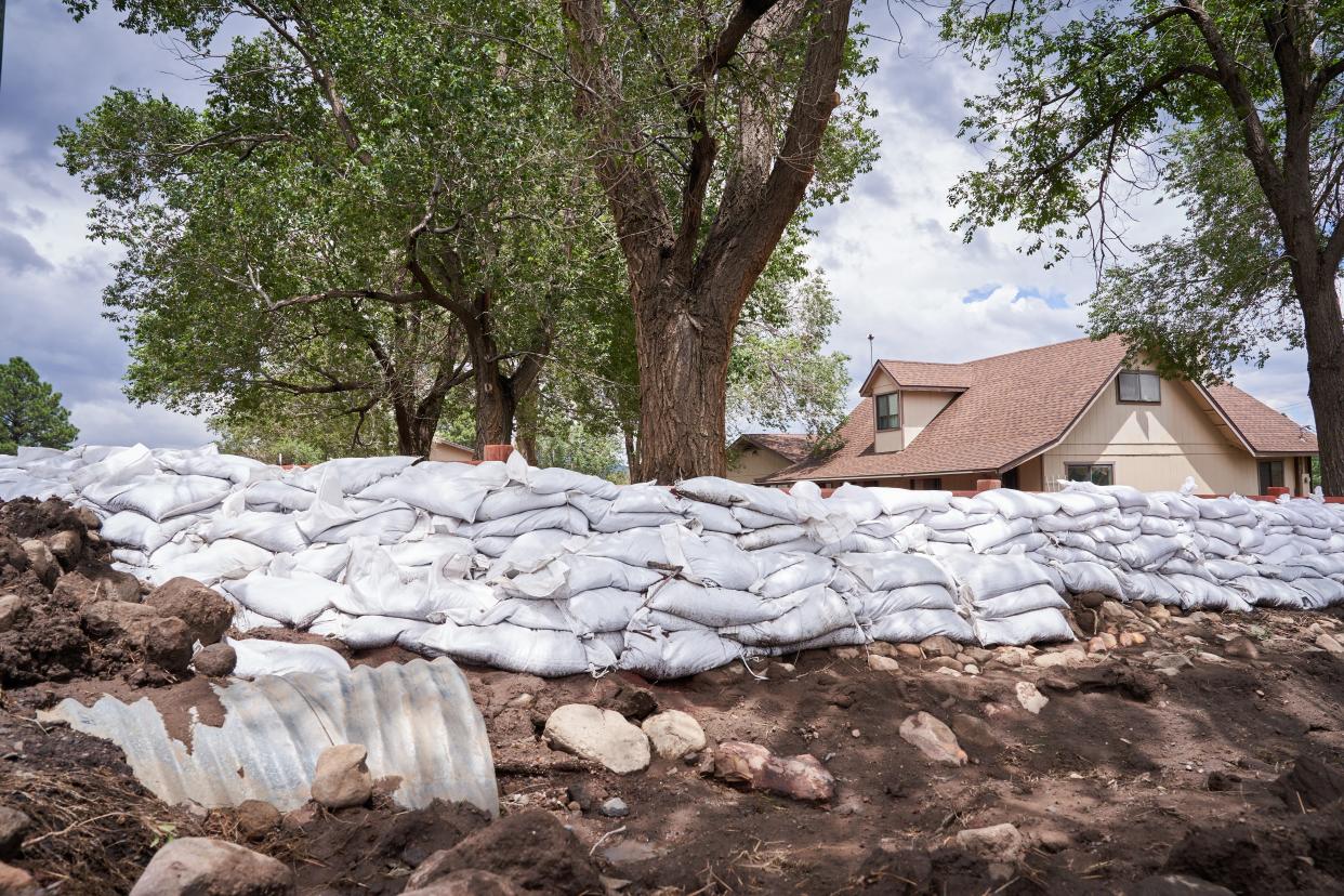 Homeowners place sandbags in front of their Flagstaff homes in preparation for a week full of monsoon storms on July 25, 2022.