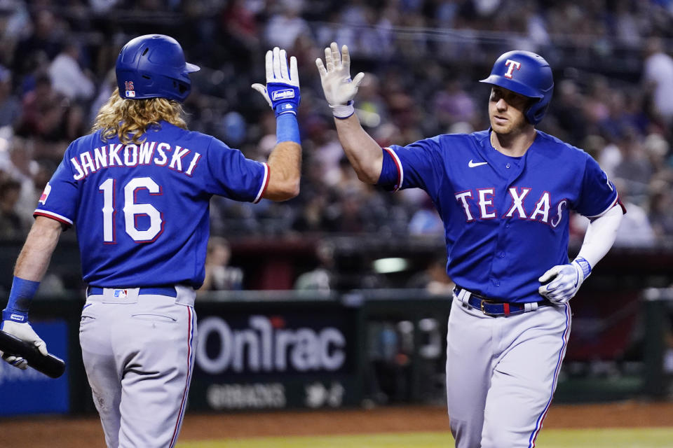 Texas Rangers' Mitch Garver, right, celebrates his home run against the Arizona Diamondbacks with Travis Jankowski (16) during the sixth inning of a baseball game Tuesday, Aug. 22, 2023, in Phoenix. (AP Photo/Ross D. Franklin)