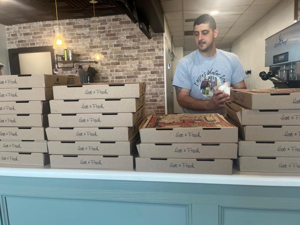 Joseph Staffieri works at his new Kirkwood Highway Fusco's Water Ice location, from behind a stack of tomato pies from Nick's Pizza. Fusco's opened its second location April 23, 2024, adding tomato pies to the menu at both locations..