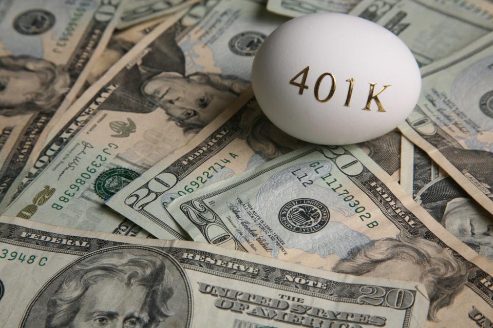 egg with 401k written on it, sitting on cash.