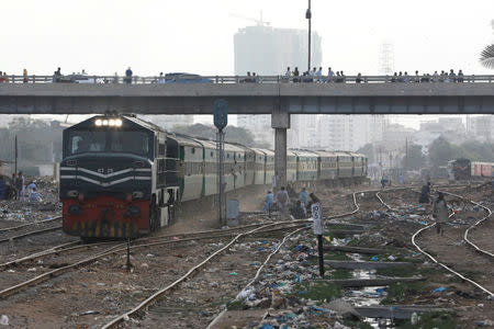 A passenger train passes under a bridge in Karachi, Pakistan September 18, 2018. REUTERS/Akhtar Soomro/Files