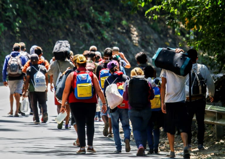 Migrantes venezolanos caminan por una carretera colombiana el 2 de febrero de 2021 (Schneyder MENDOZA)