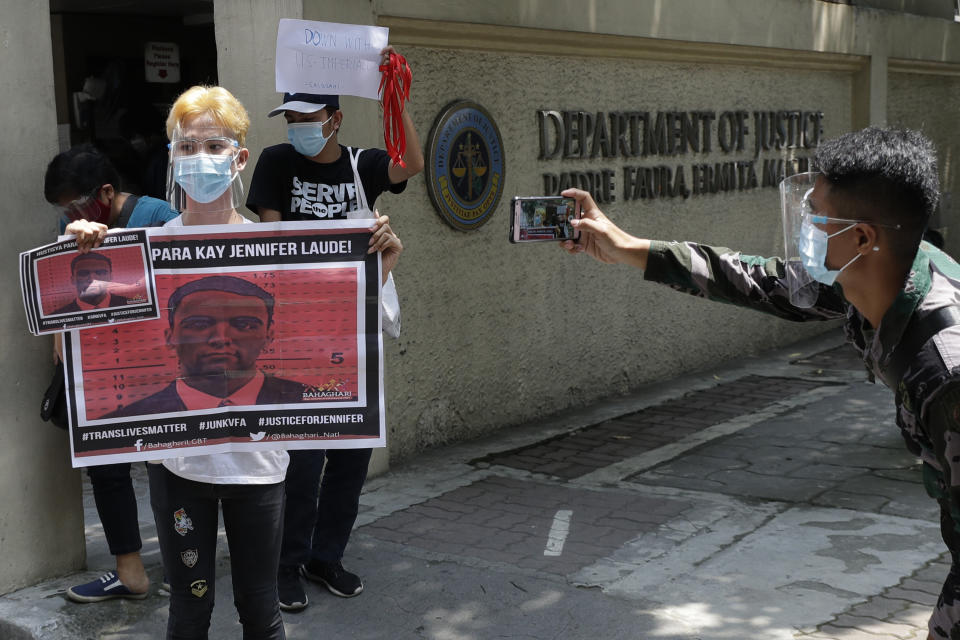 A protester holds a picture of U.S. Marine Lance Cpl. Joseph Scott Pemberton as they hold a rally outside the Department of Justice in Manila, Philippines on Thursday, Sept. 3, 2020. A Philippine court has ordered the early release for good conduct of Pemberton convicted in the 2014 killing of a transgender Filipino which sparked anger in the former American colony. (AP Photo/Aaron Favila)