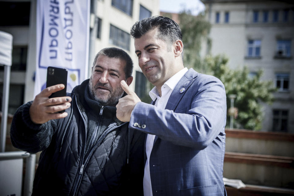 Former pro-Western Prime Minister Kiril Petkov poses with his supporter for photo during election campaign event in town of Pernik, Bulgaria, Sunday, Sept. 25, 2022. Bulgarians will go to the polls for the fourth time in less than two years in a general election overshadowed this time by the war in Ukraine, by rising energy costs and a galloping inflation. (AP Photo/Valentina Petrova)