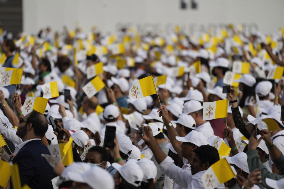 People wave Vatican flags as they wait for the arrival of Pope Francis to celebrate mass at the Bahrain National Stadium in Riffa, Bahrain, Saturday, Nov. 5, 2022. Pope Francis is making the November 3-6 visit to participate in a government-sponsored conference on East-West dialogue and to minister to Bahrain's tiny Catholic community, part of his effort to pursue dialogue with the Muslim world. (AP Photo/Alessandra Tarantino)