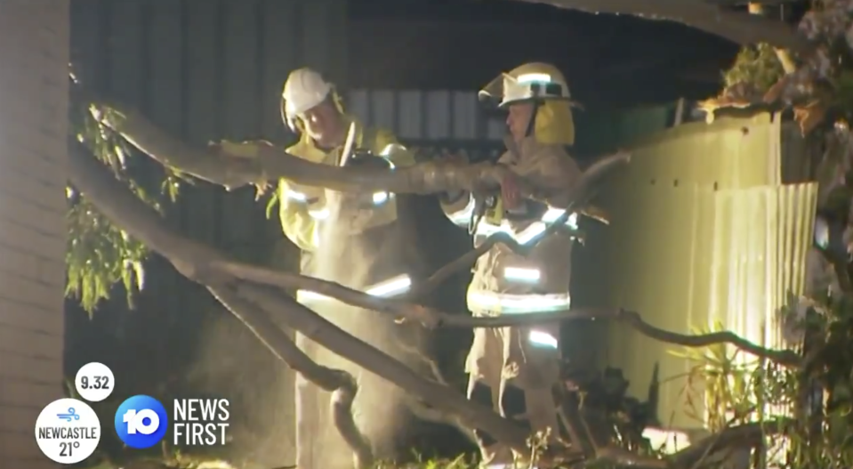 Fire fighters clear a tree off a home in Morphett Vale, Adelaide.