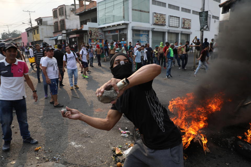 Un manifestante arroja piedras durante enfrentamientos con la Guardia Nacional Bolivariana en Ureña, Venezuela, cerca de la frontera con Colombia, el sábado 23 de febrero de 2019. (AP Foto/Rodrigo Abd)