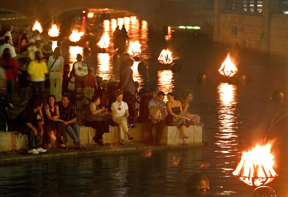 FILE - In this Saturday, May 27, 2006 file photo crowds gather along the riverfront to watch the WaterFire art installation in Providence, R.I. The work by Barnaby Evans centers on a series of 100 bonfires that blaze just above the surface of the three rivers that pass through the middle of downtown Providence. (AP Photo/Stew Milne, File)