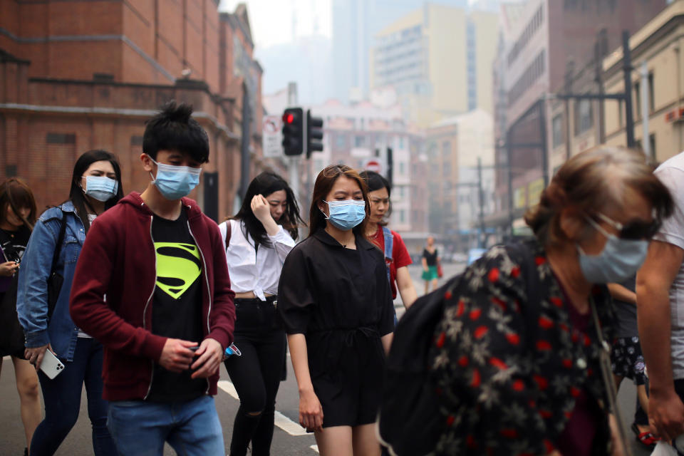 Pedestrians are seen wearing masks as smoke haze from bushfires in New South Wales blankets the CBD in Sydney, Tuesday, December 10, 2019. Source: AAP