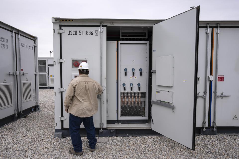 An employee works at a battery energy storage facility in Saginaw, Texas, April 25, 2023, that is owned and operated by Eolian L.P. Eolian will begin construction later this year in Portland, Ore., on projects to serve Portland General Electric, the utility that serves metropolitan Portland, the largest battery procurement of their kind outside California. (AP Photo/Sam Hodde)