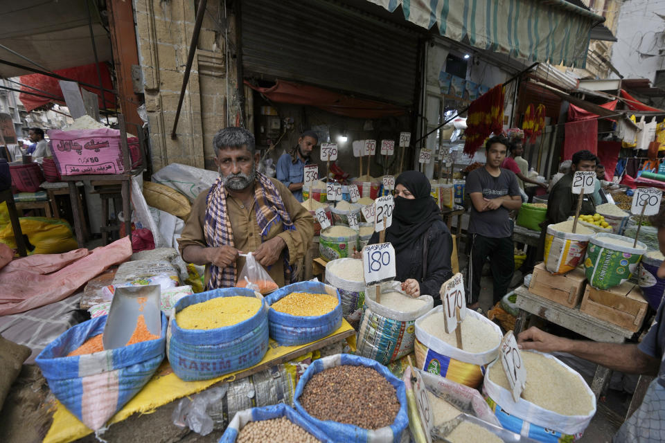 A woman buys lentil and other items at a market, in Karachi, Pakistan, Thursday, July 13, 2023. Pakistan’s finance minister on Thursday said the International Monetary Fund deposited a much-awaited first installment of $1.2 billion with the country’s central bank under a recently signed bailout aimed at enabling the impoverished Islamic nation to avoid defaulting on its debt repayments. (AP Photo/Fareed Khan)