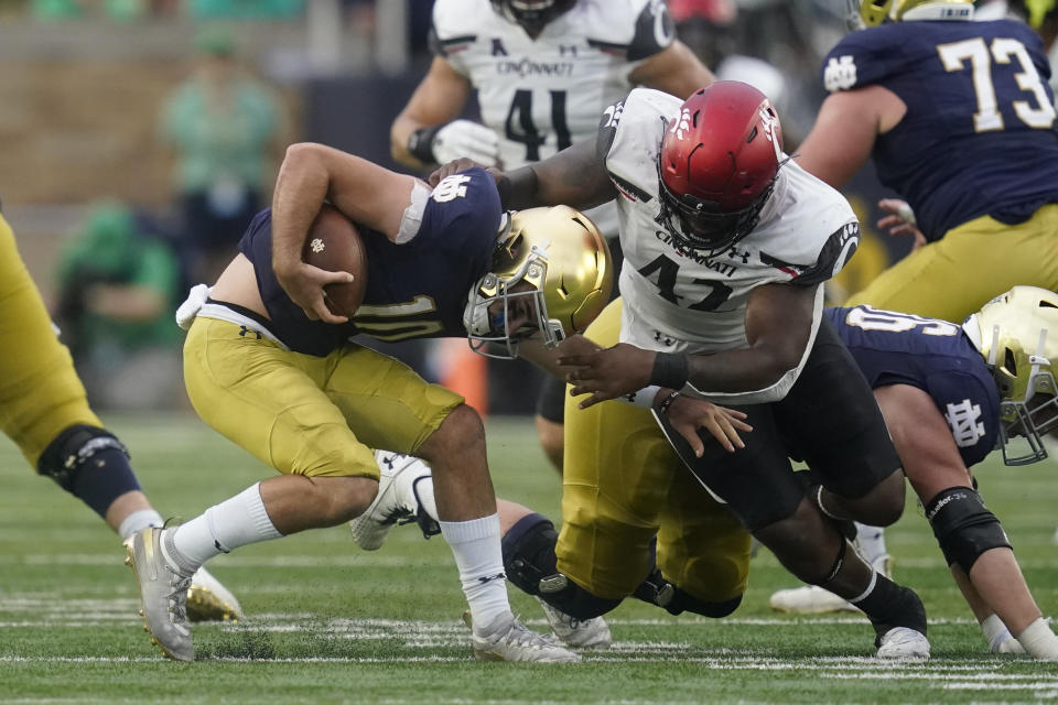 Notre Dame quarterback Drew Pyne (10) is sacked by Cincinnati's Malik Vann (42) during the second half of an NCAA college football game, Saturday, Oct. 2, 2021, in South Bend, Ind. Cincinnati won 24-13. (AP Photo/Darron Cummings)