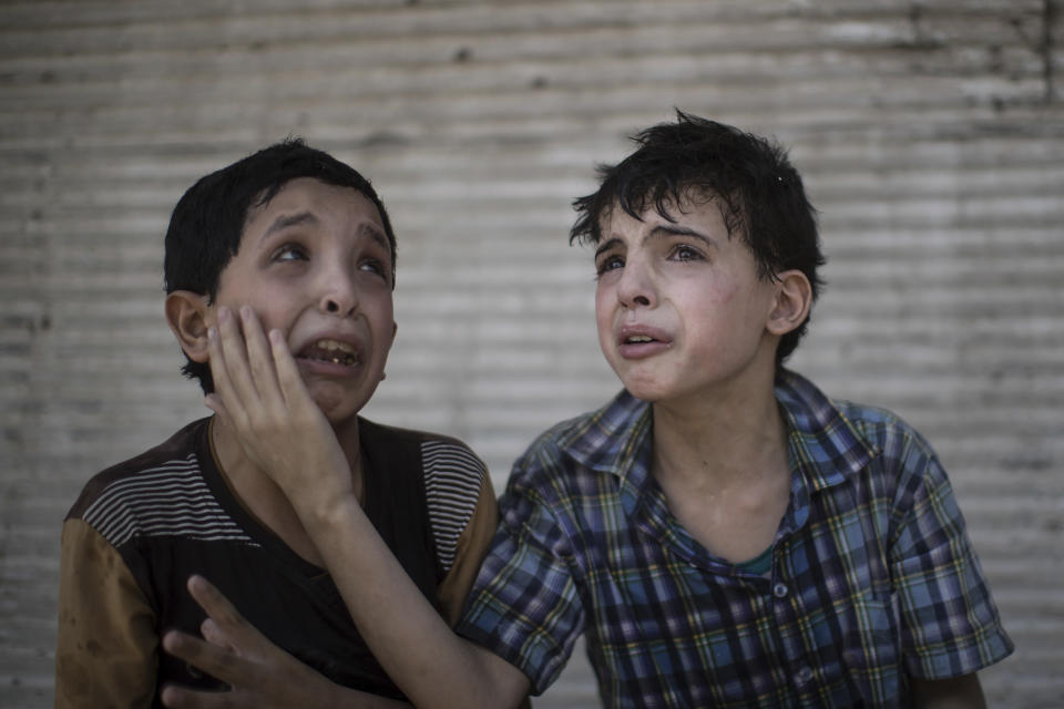 FILE - In this Saturday, June 24, 2017 file photo, Zeid Ali, 12, left, and Hodayfa Ali, 11, comfort each other after their house was hit and collapsed during fighting between Iraqi forces and Islamic State militants in Mosul, Iraq. The Ali cousins said some of their family members are still under the rubble. (AP Photo/Felipe Dana, File)