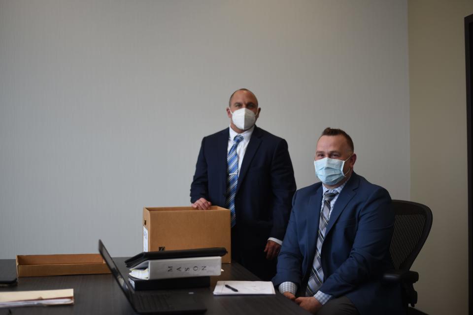 New York State Police investigators Michael Cote, left, and Samuel Lizzio with a box of documents related to the 1988 death of Karen Rew Mason at the police barracks in Latham on April 29, 2021.