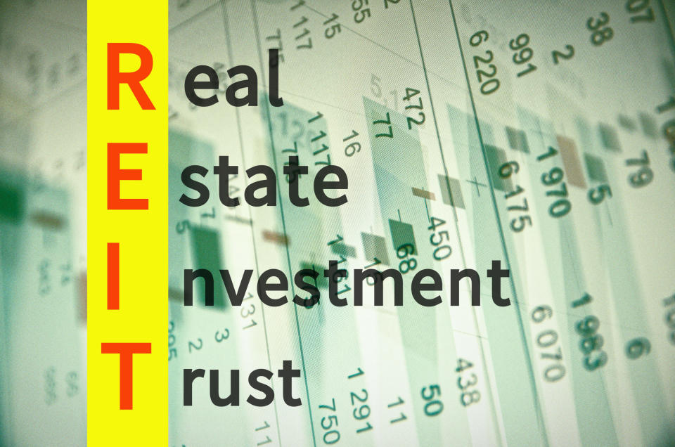 Real estate investment trust spelled out over a paper with data on it