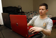 Graham Berryman looks at his laptop at his apartment in Springfield, Mo., on Thursday, Oct. 21, 2021. Berryman is a lawyer that his struggled to find work during the pandemic after he was let go by his previous firm in August 2020. He has lived off savings since losing his job, but the money may not last much longer. (AP Photo/Bruce E. Stidham)