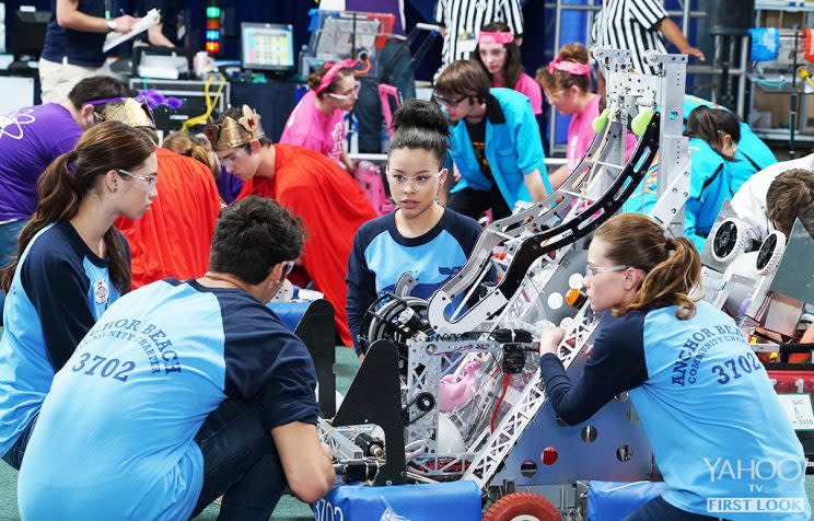 Penny, Jesus, Mariana, and Emma gather around to discuss how to fix the problem with their robot. (Credit: Eric McCandless/Freeform)