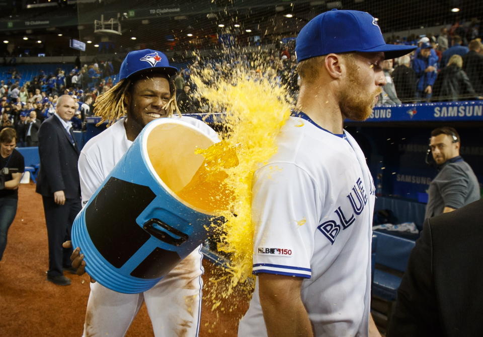 Toronto Blue Jays' Vladimir Guerrero Jr. douses teammate Brandon Drury after Drury hit a walkoff home run to defeat the Oakland Athletics during the ninth inning of baseball game action in Toronto, Friday, April 26, 2019. (Mark Blinch/The Canadian Press via AP)