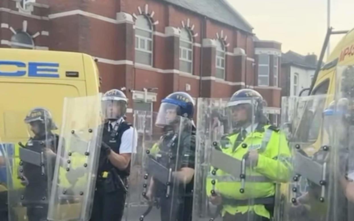 Officers form a wall with riot shields