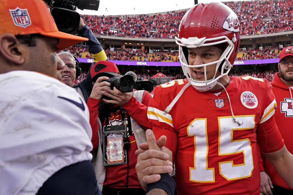 Kansas City Chiefs quarterback Patrick Mahomes (15) and Denver Broncos quarterback Russell Wilson (3) greet each other after an NFL football game Sunday, Jan. 1, 2023, in Kansas City, Mo. (AP Photo/Charlie Riedel)